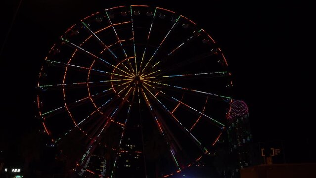 The Ferris wheel in Batumi shimmers with different colors at night. Sights of Georgia: Batumi, Georgia - December 8, 2023
