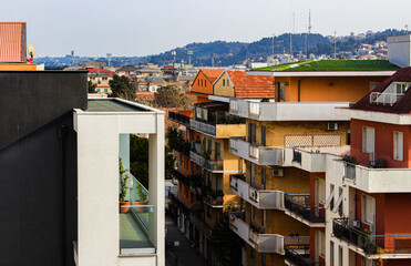 Street with houses in the Italian city against the background of hills