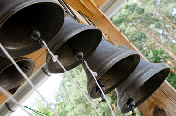 Church bells hang in a row, the bells are ringing. Church bell, several church bells in the monastery. Several metal church bells, bell ringing.