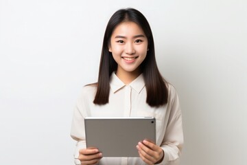 smiling happy female student holding a notebook in her hands on light background