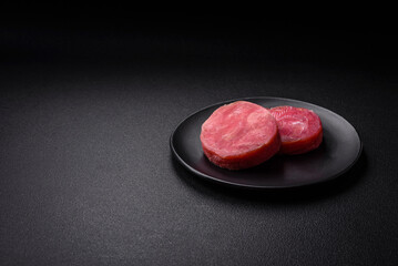 Round shape steaks of raw juicy tuna with salt and spices