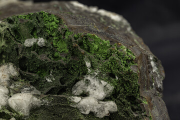 Rich Green Epidote Mineral in Focus Against Dark Surface for Geological Study