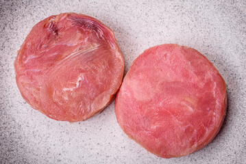 Round shape steaks of raw juicy tuna with salt and spices