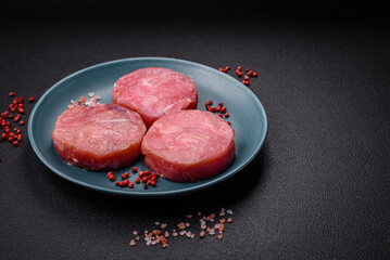 Round shape steaks of raw juicy tuna with salt and spices
