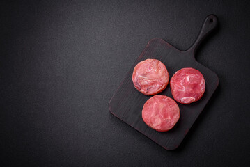 Round shape steaks of raw juicy tuna with salt and spices