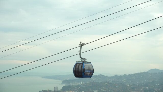 Blue funicular cable car offers a scenic touristic ride to reach destination, against sky background. Public transportation and recreational experience, perfect vacation