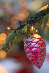 Close-up of beautiful fir branches with baubles or balls, Christmas decorations and toys, lights or garlands, background of Christmas holidays. Selective focus