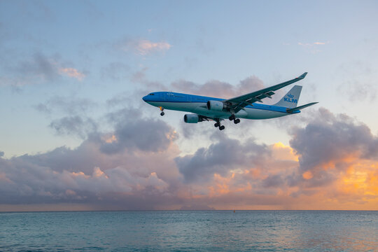 KLM Airbus 330 flying over Maho Beach before landing on Princess Juliana International Airport SXM at sunset on Sint Maarten, Dutch Caribbean. 