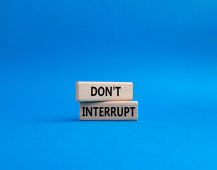 Dont interrupt symbol. Concept word Dont interrupt on wooden blocks. Beautiful blue background....