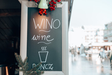 Wine text on blank black signboard, sign board hanging on cafe or shop at Christmas market,...
