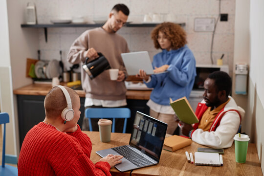 Diverse group of young people studying in kitchen interior at college dorm everyday scene