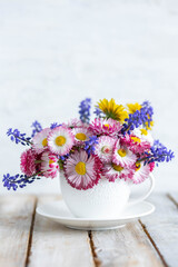 Fototapeta na wymiar Colourful floral composition for Mother's or Women's day, anniversary, birthday. Summertime inspiration. Greeting holiday card template with summer fresh bright daisy flowers in a white porcelaine mug