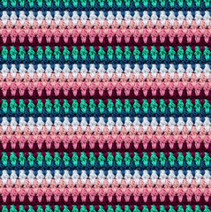 Seamless knitted texture in afghan style. The pattern is crocheted from multicolored cotton yarn. Textured blanket.