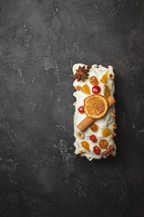 Delicious Christmas cake with citrus and cinnamon on a dark background. Mockup.