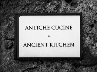 a label hanging on the wall indicates the ancient kitchens of the Bracciano Castle