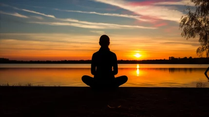 Foto op Canvas A person meditating in a sunset backdrop, finding inner peace and tranquility amidst the beauty of nature. © OKAN