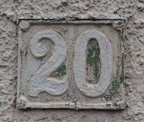 Vintage grunge square metal rusty plate of number of street address with number. Close up, brand.