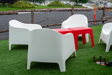 Four large white weather resistant chaise loungers made of plastic, are stackable furniture, next...