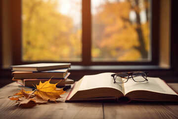 books and autumn leaves on wooden desk