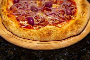 Traditional Calabrian sausage pizza with red onion and black olives