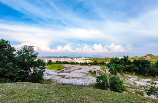 Particular view from beside the road at the UiTM Puncak Alam, Selangor roadside landscapes with sparse buildings and an immense view over the lands as far as the eye can see.

