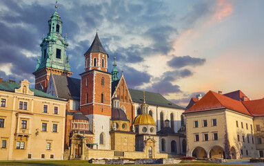 Wawel castle in Krakow, Poland. Towers of Catholic temple. Picturesque territory and buildings architecture. Winter day with evening warm sunshine lighting. Sky dramatic clouds