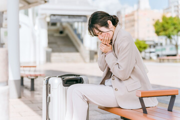 駅・旅行中に体調不良になったビジネスウーマン
