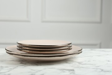 Beautiful ceramic plates on white marble table indoors, space for text