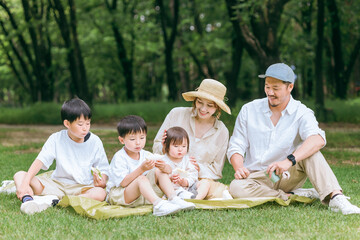 夏休みにレジャー・ピクニックでランチを食べる家族・ファミリー・親子

