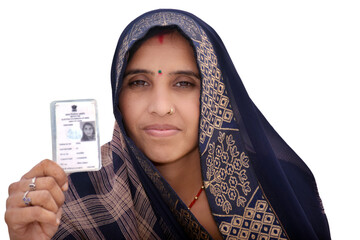 Indian rural woman wearing a sari with smiling face shows her blurred voter card in her hand,...