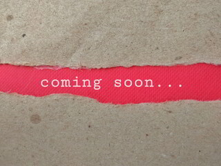 Coming soon text on old ripped paper