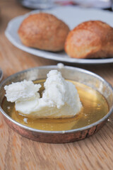 butter cream and honey in a bowl on table .
