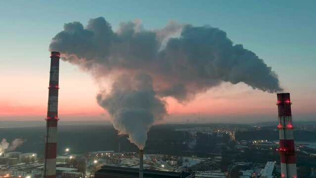 Aerial sunset hyperlapse of heating plant and thermal power station. Combined modern power station for city district heating and generating electrical power. Industrial zone from above.