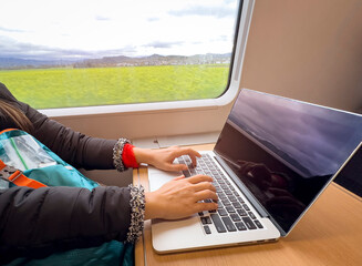 Nomad digital woman hand  as she is a freelance working  a vacation with laptop in  the train
