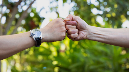 Deal of teamwork with the Man hand a fist bump commit as get together in the office.