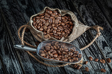 Coffee Beans In Sack With Scoop On Vintage Wood Background.