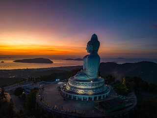 Aerial view scenery yellow light at horizon at sunrise in front of Phuket Big Buddha.the golden sun shines through the clouds..The beauty of the statue fits perfectly with the charming nature.
