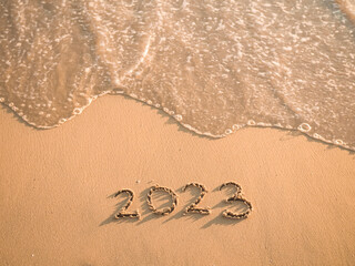 2023 year written on the beach in the sunset time. Goodbye 2023 concept
