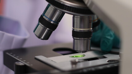 laboratory setting with colorful liquids in test tubes and a person wearing a lab coat and gloves.