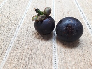 Fresh mangosteen fruit isolated on twig background, copy space