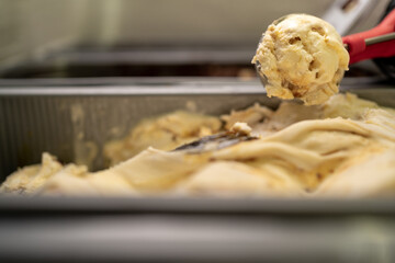 Ice cream display. Salesman scooping a scoop of vegan ice-cream into a waffle cone