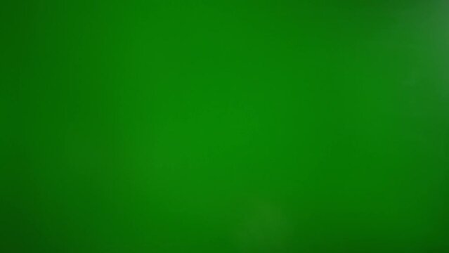 A man makes a fig with his fingers on a green background. The concept of resistance and contempt