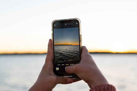 A Sunset Being Photographed With A Smartphone