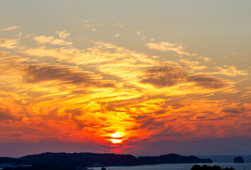 美しい夕焼け　雲の合間に見えるオレンジ色の太陽