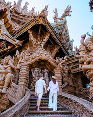 A diverse multiethnic couple of men and women visit The Sanctuary of Truth temple in Pattaya...