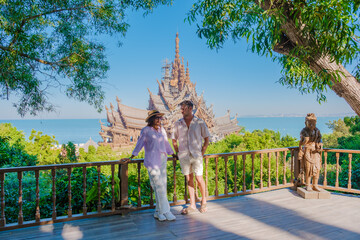 A diverse multiethnic couple of men and women visit The Sanctuary of Truth wooden temple in Pattaya...