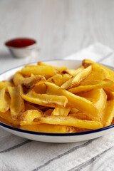 Homemade French Fries with Ketchup on a white wooden background, side view. Close-up.