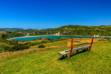Obraz na płótnie Canvas A view from Islotes de Punihuil with a bench in foreground, Chiloe - Islotes de Punihuil, Lake District, Chile