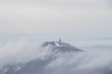 Highest peak of Beskydy mountains Lysa hora under the morning fog and white snow cover. Winter months on planet Earth