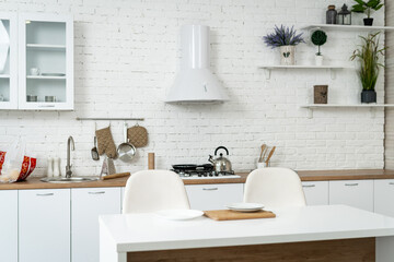Fototapeta na wymiar A Modern Kitchen with a White Brick Wall and Stylish White Chairs. A kitchen with a white brick wall and white chairs